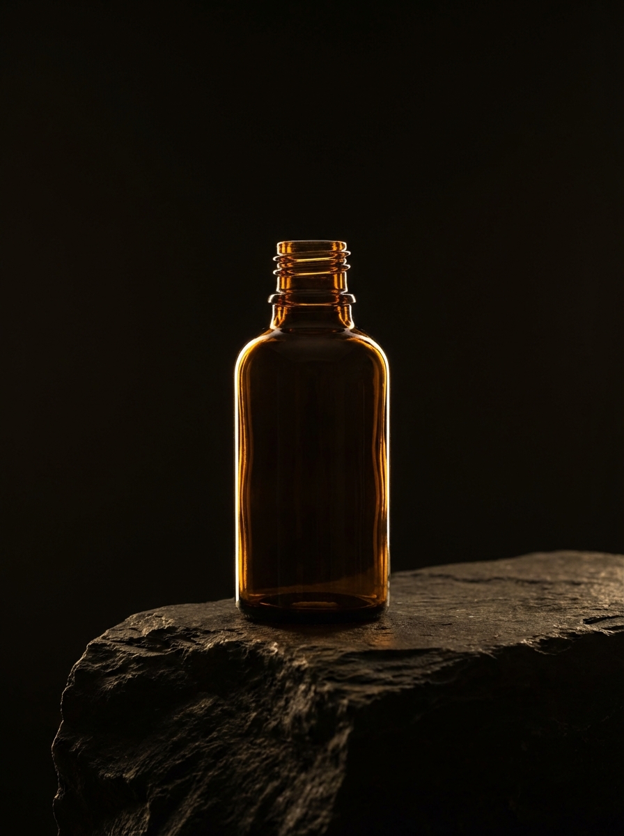 A single, minimalist amber glass essential oil bottle standing on a dark, textured slate podium. Dramatic rim lighting, cinematic studio photography, 8k resolution, elegant and premium brand aesthetic.