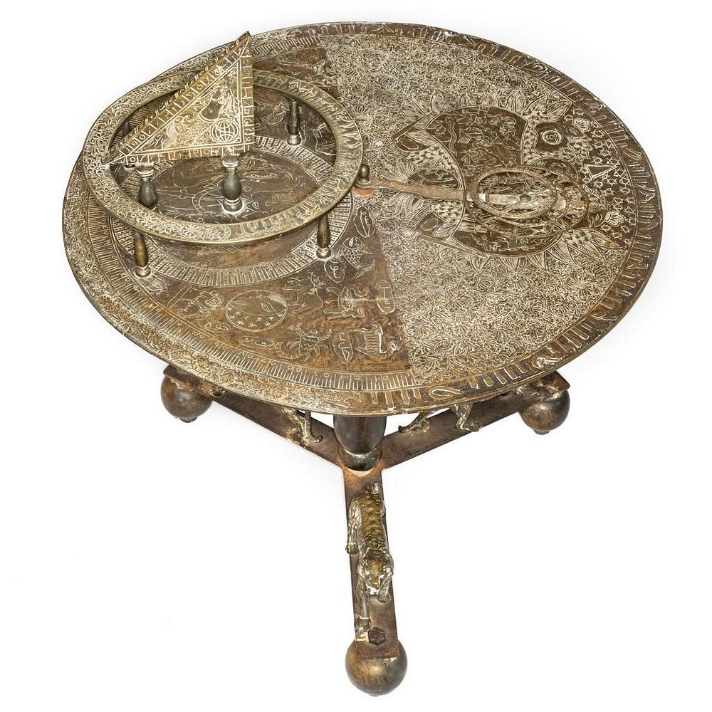 Brass ancient astrolabe on a wooden table with astronomy charts