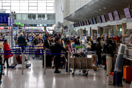 busy chaotic airport terminal with frustrated passengers waiting, photorealistic, muted tones