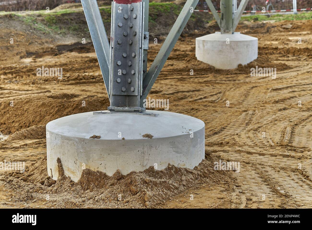high voltage transmission tower foundation construction site, concrete footing, industrial infrastructure, daytime