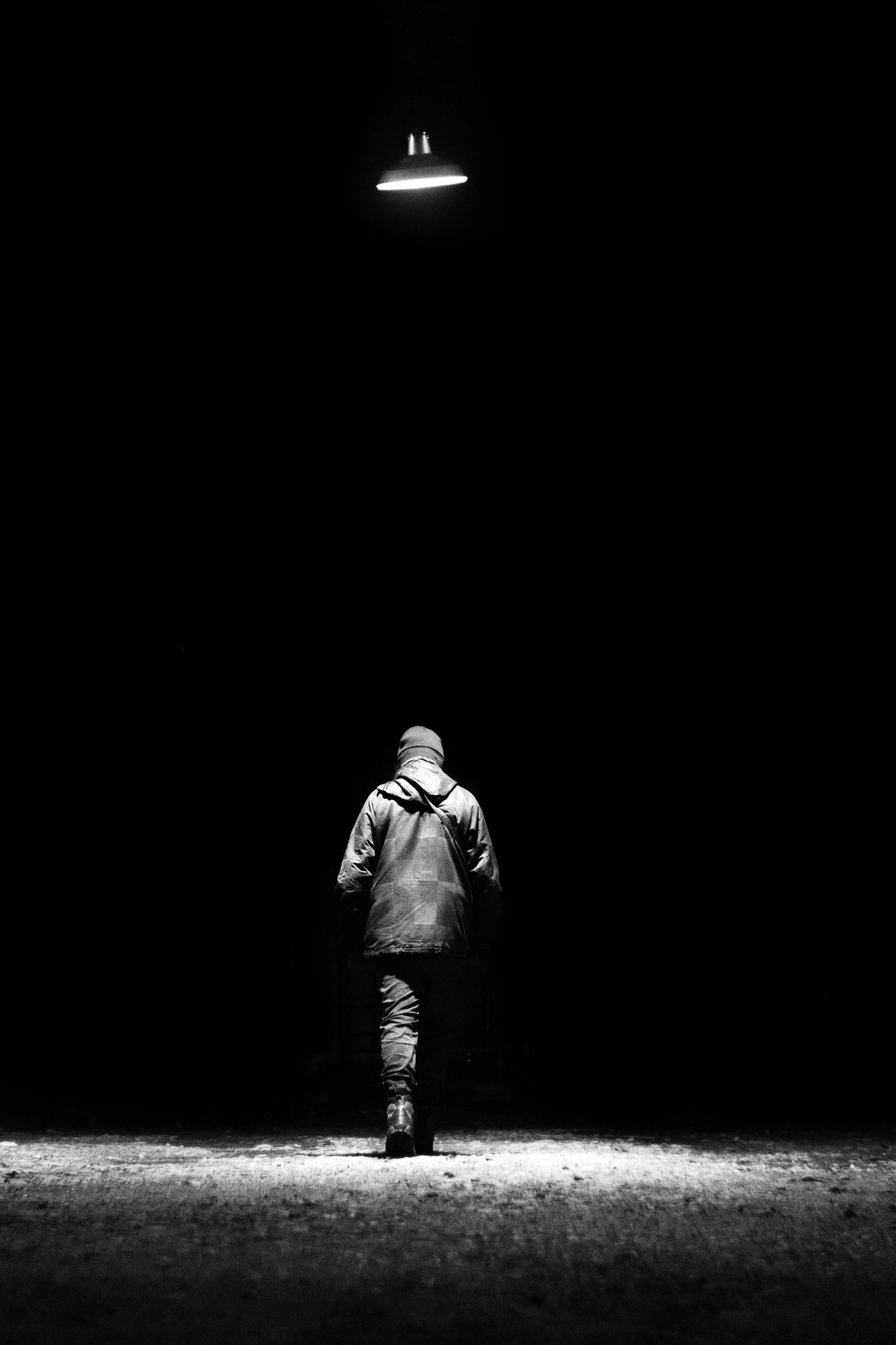 Rod Wave walking away into the spotlight, atmospheric, silhouette