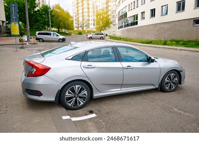 Silver Honda Civic parked on street, side view