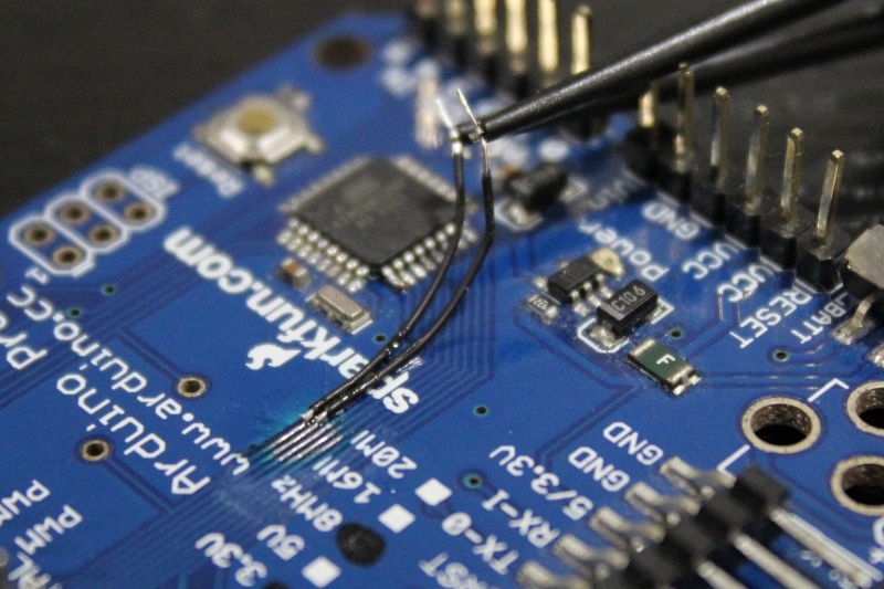 Saleae logic analyzer connected to a microcontroller development board, close up photography