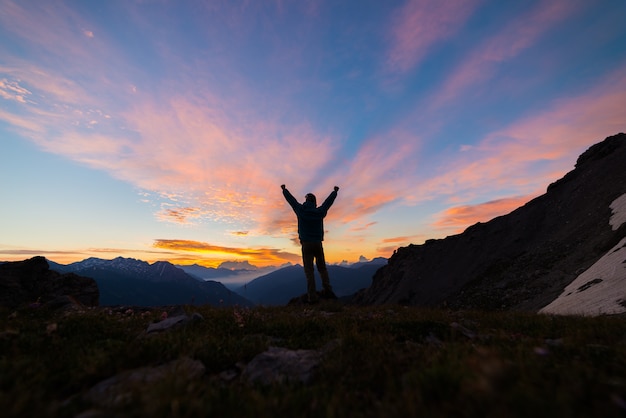 person standing on top of a mountain looking at a sunrise, success concept, photography style