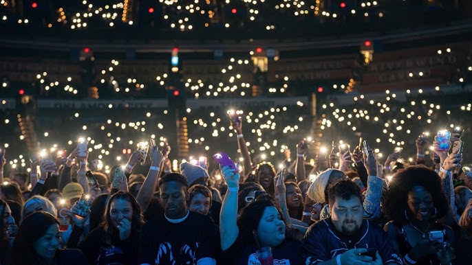 Rod Wave concert audience singing along with cell phone lights, atmospheric