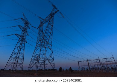 electrical substation and high voltage transmission lines against a blue sky, energy infrastructure, photorealistic