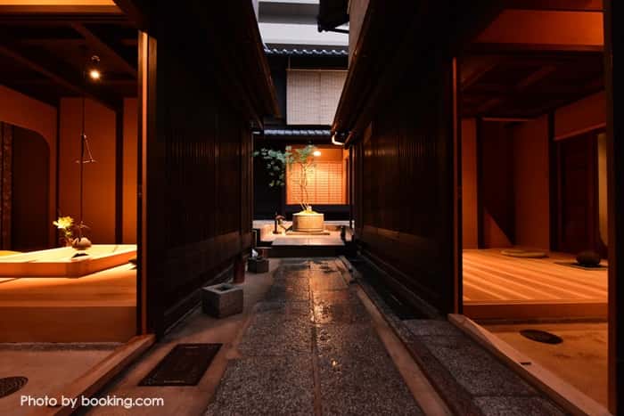 Modern ryokan interior in Kyoto with tatami mats and shoji screens, warm lighting